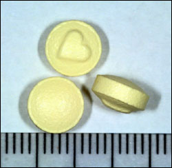 image of yellow tablets with a raised heart logo on one side, suspected Ecstasy