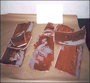 image of a large green suitcase with an internal framework-liner consisting of a hard, reddish colored, woodlike material, suspected to contain heroin