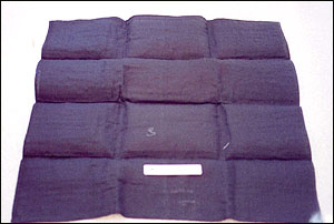 image of the hard, black cheesecloth-like insert that had an opium-like odor found in each blanket.