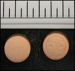 photo of 57 orange colored tablets with a "ying/yang" logo